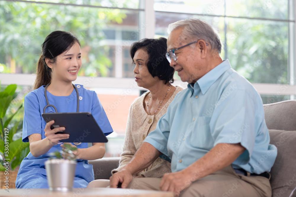 Asian woman doctor work in nursing home with digital tablet consults service to patient explains health care symptoms and help elderly family, Concept of elderly care, health care and insurance.