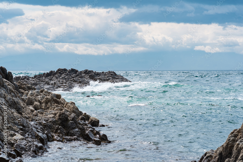 rocky seashore, gray basalt cliffs on the shore