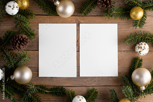 Two Christmas 5x7 card mockup template with fir twigs and Christmas decoration on wooden background. Design element for Christmas and New Year congratulation, greeting or invitation card