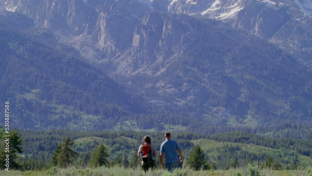 Impressive wilderness with pristine alpine meadows and towering granite peaks in Grand Teton National Park, WY, USA. Adventurous backpackers wandering along rocky landscape. High quality 4k footage Impressive wilderness with pristine alpine meadows and towering granite peaks in Grand Teton National Park, WY, USA. Adventurous backpackers wandering along rocky landscape. High quality 4k footage
