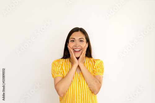 attractive young brunette woman in yellow shirt smiling on white background copy space. happy positive brunette. holiday, surprise concept