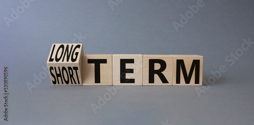 Long term vs Short Term symbol. Turned wooden cubes with words Long term and Short Term. Beautiful grey background. Business concept. Copy space. photo