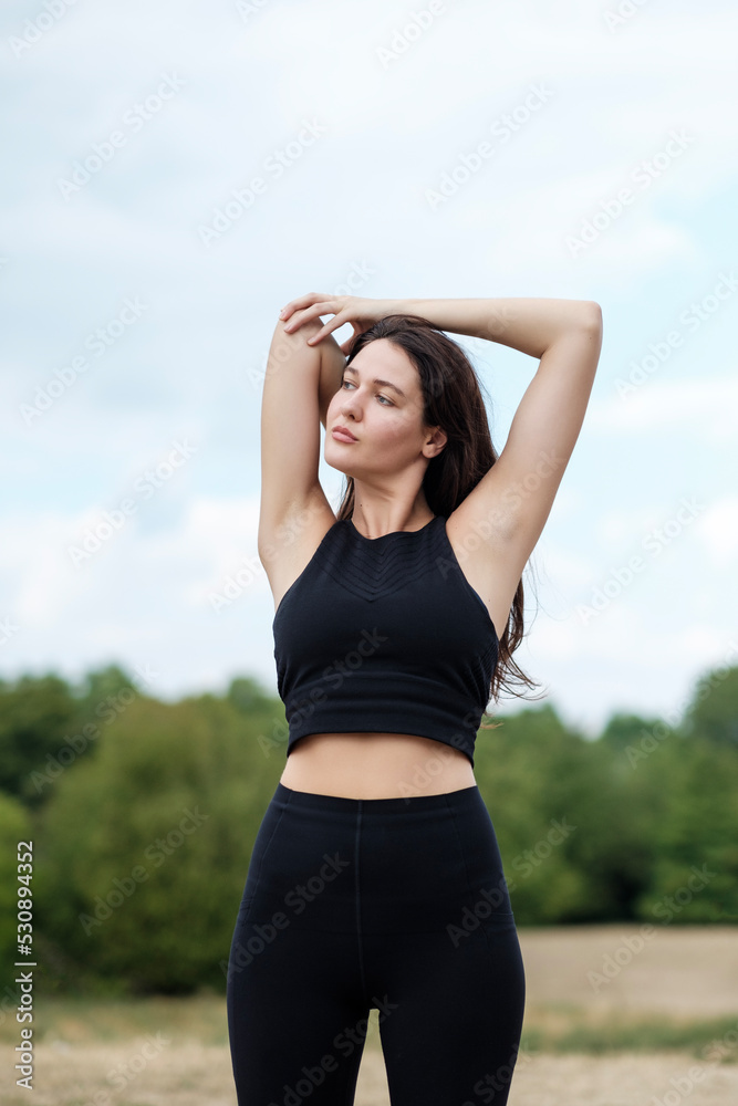 A young caucasian woman is doing yoga and stretching in a forest in London. A young caucasian woman is doing yoga and stretching in a forest in London.