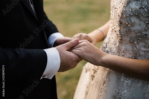 Bride and groom holding hands on the wedding. © ClauRiveraE