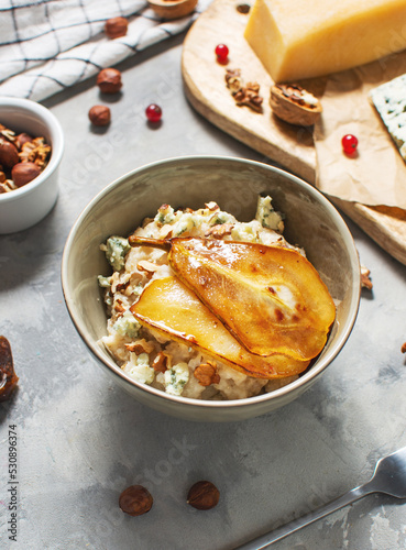 Pear and gorgonzola oatmeal with walnuts on concrete table