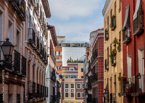 Exterior view of beautiful historical buildings in Central Madrid, Spain, Europe. Colorful street scene in the Letras neighborhood of the Spanish capital. Facade of traditional heritage buildings.