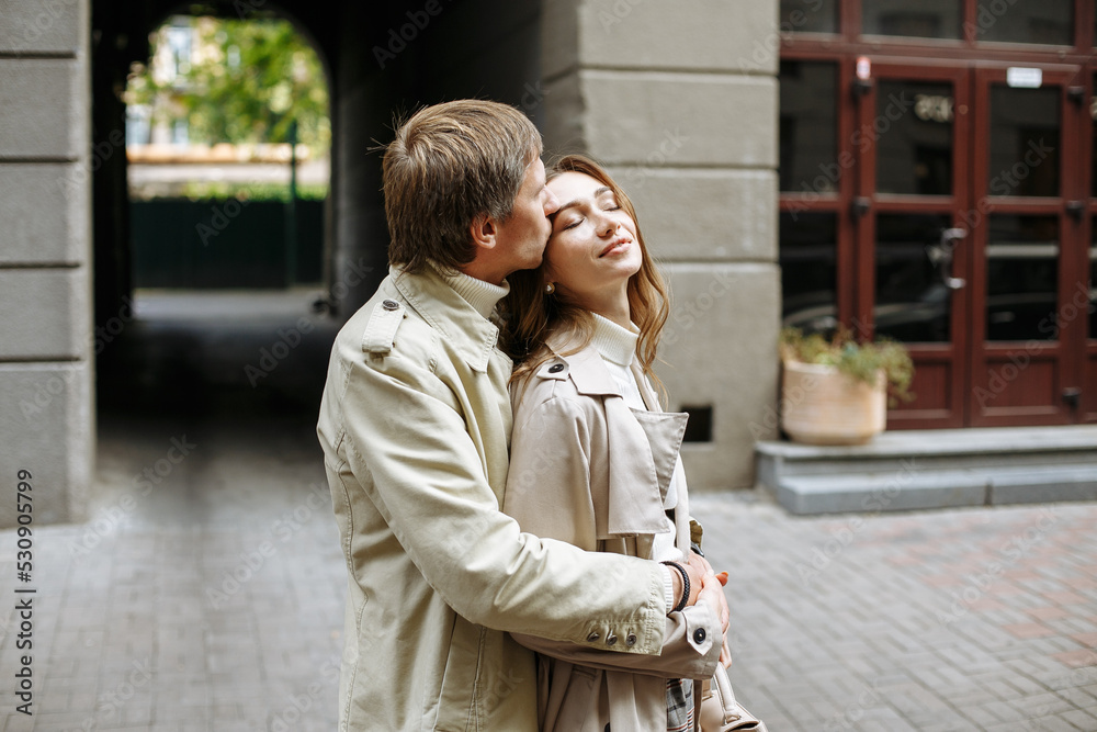 Naklejka premium a couple in love walks in the autumn city against the background of buildings