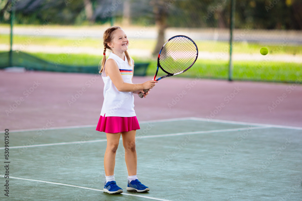 Child playing tennis on outdoor court