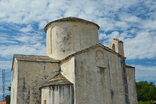 Side view of pre-romanesque Church Of The Holy Cross in Nin, Croatia, during cloudy summer day. photo