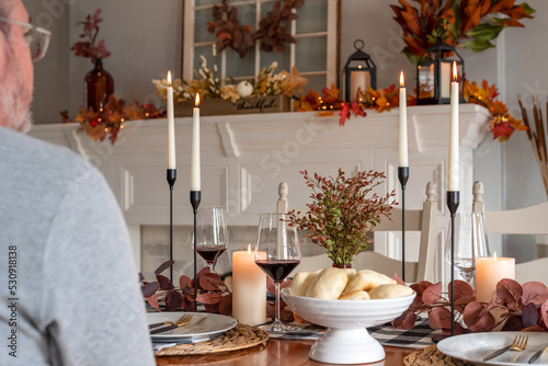 Man sitting at a festively decorated dining table for a holiday meal