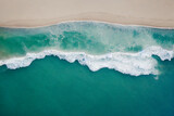 Aerial view of the sandy beach near the sea with waves.  Top view of  incredibly beautiful azure water 