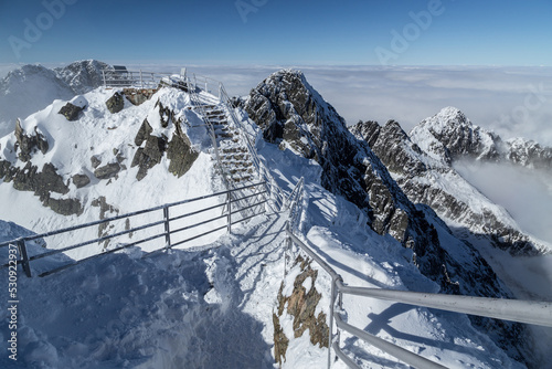 Snowy viewpoint walkway across High Tatra Mountain ridge in winter, Lomnicky Peak Stit, Slovakia photo