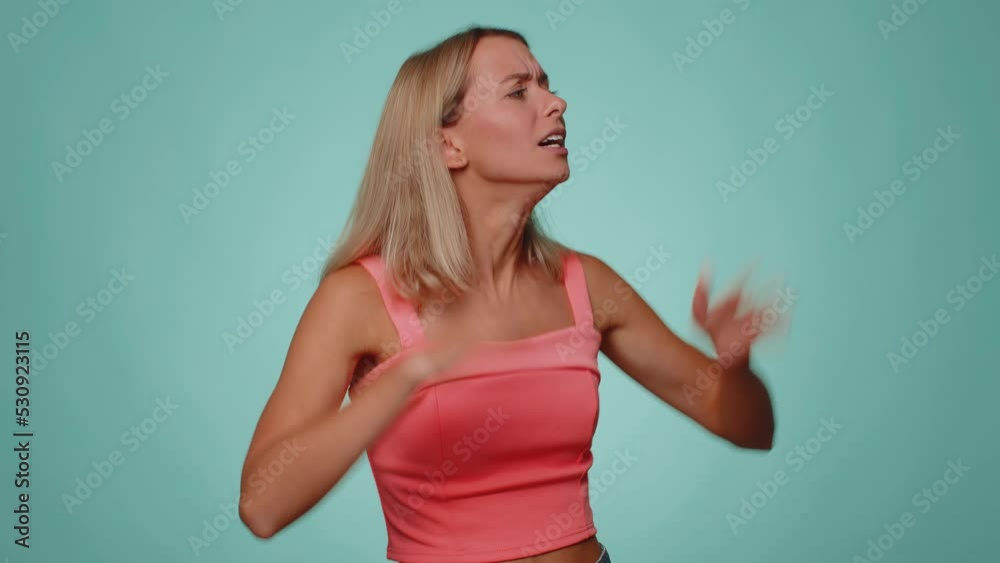 Woman screams from stress tension problems feels horror hopelessness fear surprise shock expresses gestures rage. Young slim thin slender girl isolated alone on blue studio wall background. Lifestyle Woman screams from stress tension problems feels horror hopelessness fear surprise shock expresses gestures rage. Young slim thin slender girl isolated alone on blue studio wall background. Lifestyle