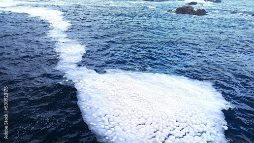 Rastro de espuma en el agua del mar en Galicia photo