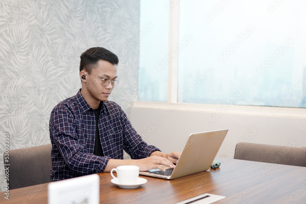 Serious office employee sitting at desk with laptop, preparing report, making online presentation looking focused at work. The concept of using technology Serious office employee sitting at desk with laptop, preparing report, making online presentation looking focused at work. The concept of using technology