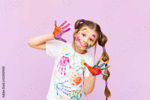 A child stained in multicolored paints will have to be creative. The concept of children s creativity on a pink isolated background.