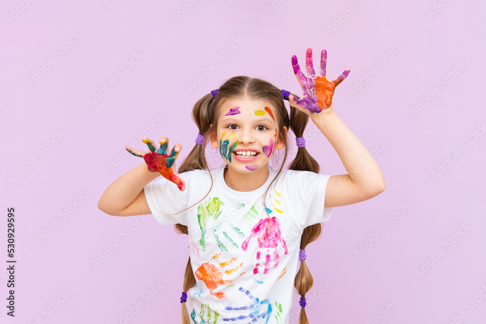 A child stained in multicolored paints will have to be creative. The concept of children's creativity on a pink isolated background.