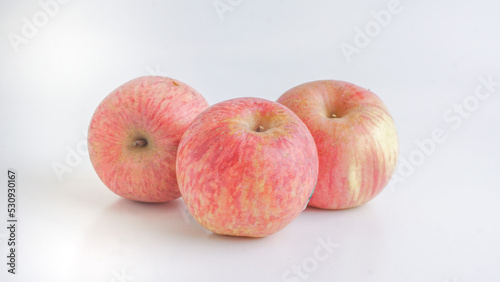 Three fresh Fuji apples on white background. Selective Focus