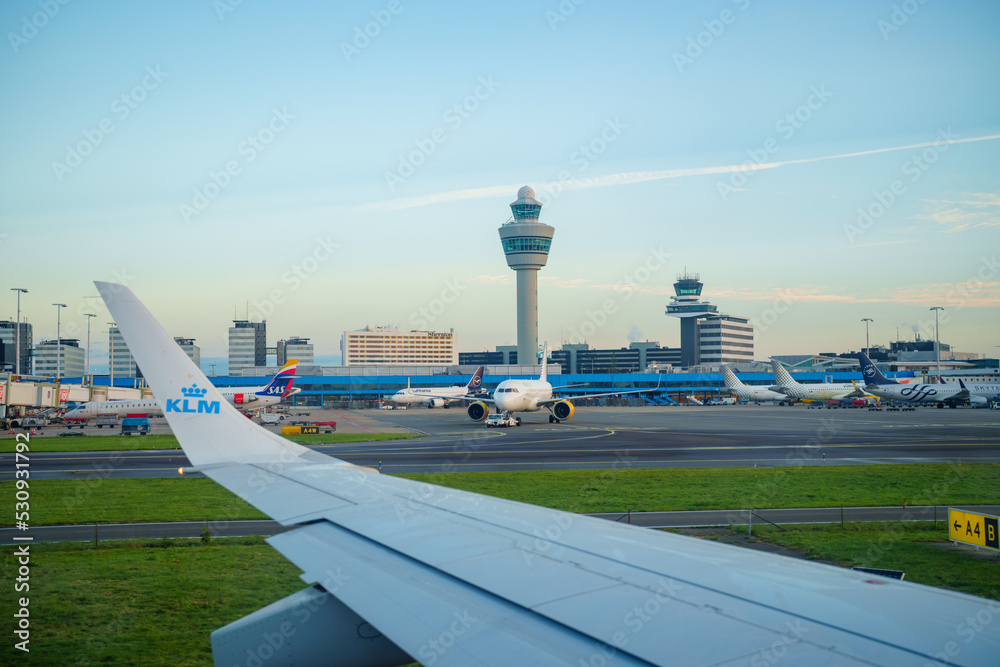 Obraz premium View of Amsterdam Airport Schiphol tower as seen from airplane taxiing on runway