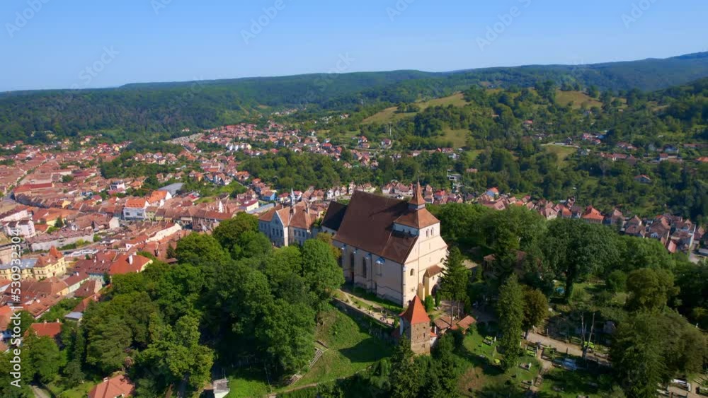 Aerial drone view of the Historic Centre of Sighisoara, Romania. Old buildings, Church on the Hill, surrounded by greenery Aerial drone view of the Historic Centre of Sighisoara, Romania. Old buildings, Church on the Hill, surrounded by greenery