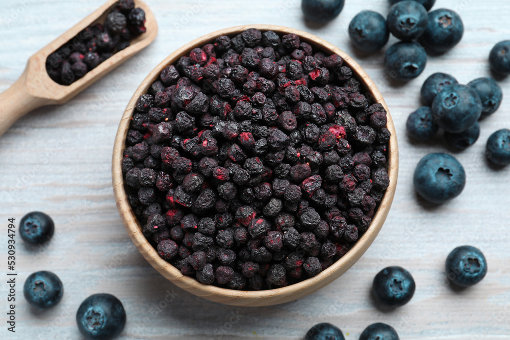Freeze dried and fresh blueberries on white wooden table, flat lay Freeze dried and fresh blueberries on white wooden table, flat lay