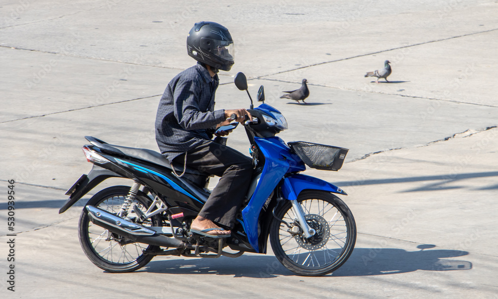 A man with helmet rides a motorcycle at the road