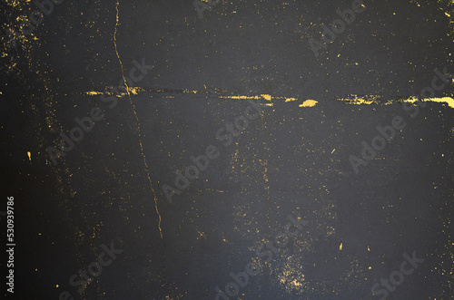 Background designed with golden metal cracks shining on grungy dark gray concrete texture. Dark gray and gold background.