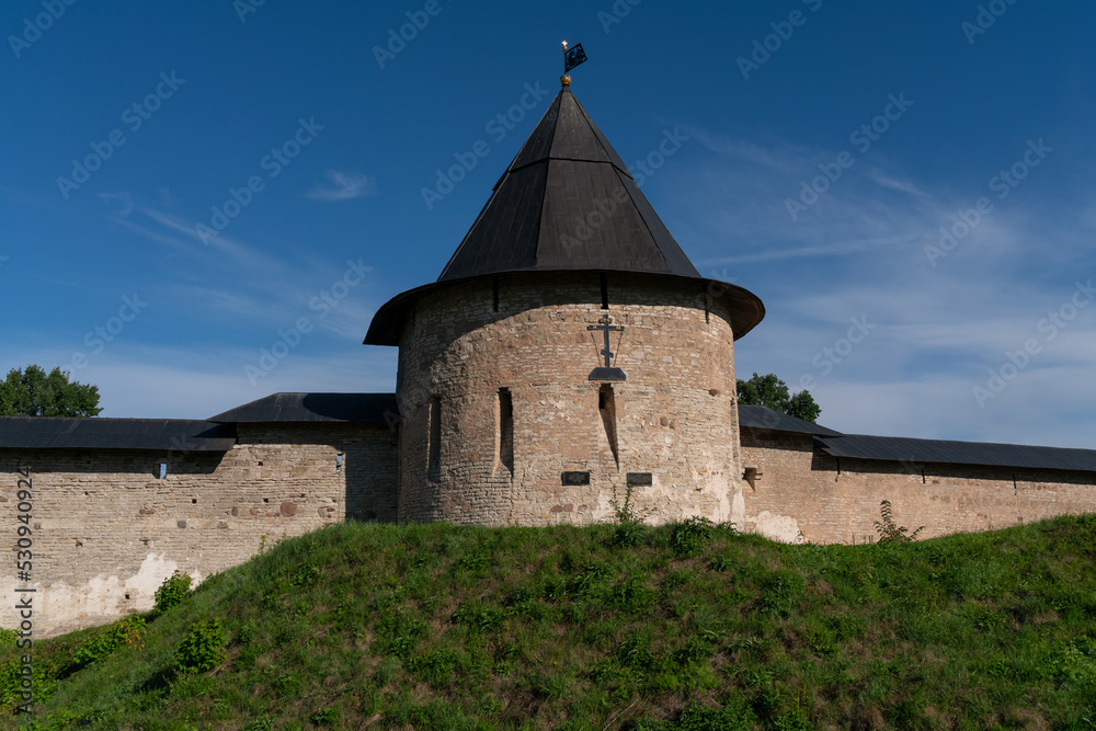 View of the Izborsk Tower of the Holy Dormition Pskov-Pechersk Monastery on a sunny summer day, Pechory, Pskov region, Russia