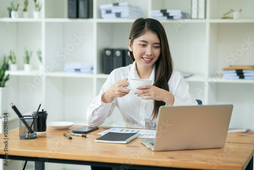 Asian businesswoman chatting with customers via laptop online