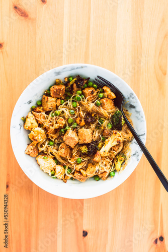healthy plant-based food, vegan noodles stir fry with broccoli peas and marinated tofu chunks