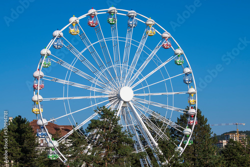 A Colorful Ferris Wheel Over Blue Sky.