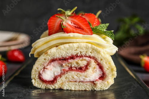 Board with tasty strawberry roll cake, closeup