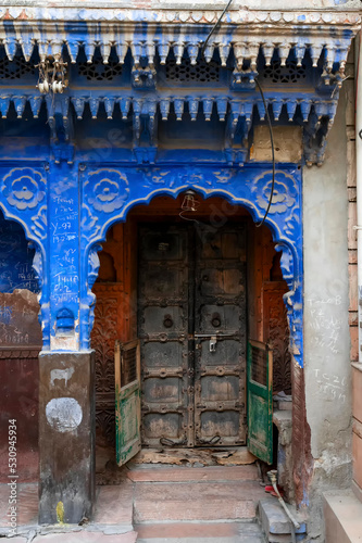 Traditional wooden door and blue coloured house of Jodhpur city, Rajsthan, India. Historically, Hindu Brahmins used to paint their houses in blue for being upper caste, the tradition follows. © mitrarudra
