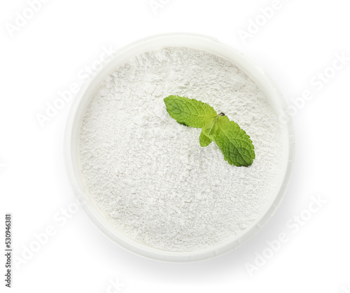 Bowl of tooth powder with mint on white background