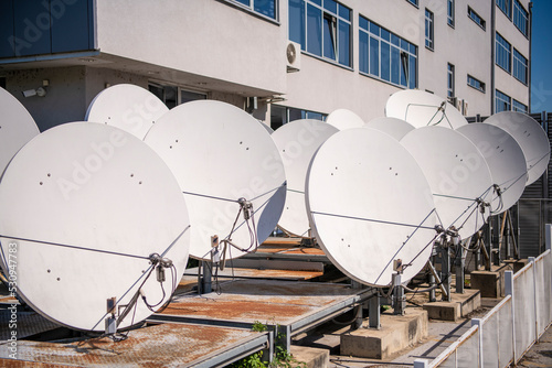 Row of Many white parabolic satellite antenna dishes. photo