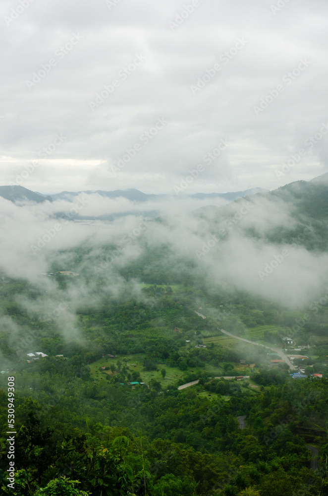 green mountain top view with village in cloudy day