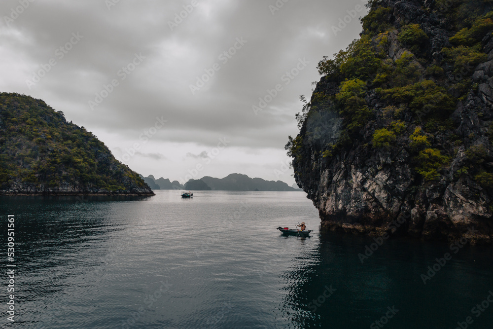 Ha Long Bay, Vietnam - March 1st, 2020 : Views on the karst mountains of Ha Long Bay on a cloudy day 