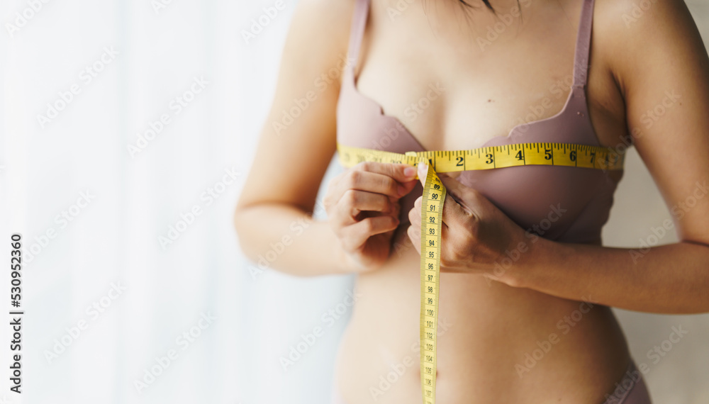 Women's breast measure concept. A woman wearing a bra to measure her chest circumference. Women's breast measure concept. A woman wearing a bra to measure her chest circumference.
