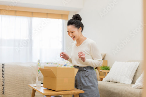 ダンボールを開ける女性