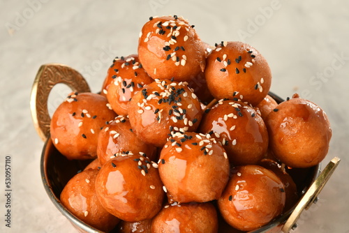 luqaimat or lokma. Freshly fried Lokma (luqma - arabic) piled high a popular middle eastern dessert of small dough balls deep fried then coated in sugar or honey syrup
