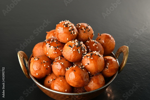 luqaimat or lokma. Freshly fried Lokma (luqma - arabic) piled high a popular middle eastern dessert of small dough balls deep fried then coated in sugar or honey syrup
