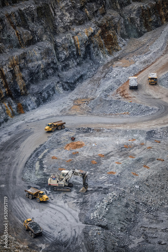 Work of trucks and the excavator in an open pit on gold mining © CA[P]IXEL