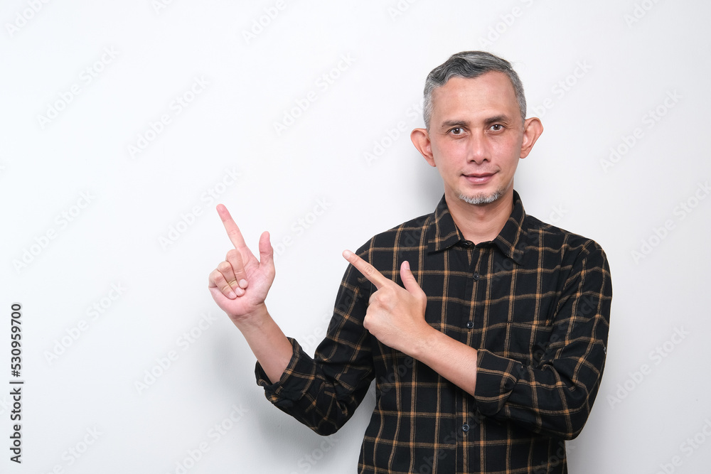 Portrait of Adult Asian Man pointing hands and finger to the side. (explain something).
Portrait of Adult Asian Man pointing hands and finger to the side. (explain something).