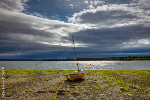 Photo Yellow sailboat on the shoal in the port in Findhorn, Scotland.