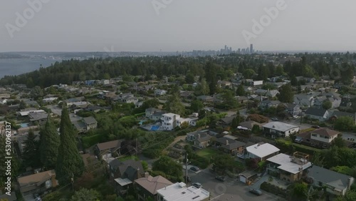 Slow aerial flyover of neighborhoods in Alki Point with downtown Seattle in the background. photo