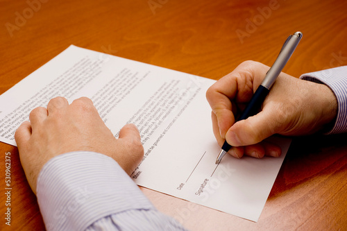 hand of a man signing a contract