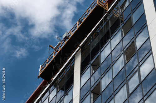 Suspended platform without workers on a glass and steel facade of skyscraper