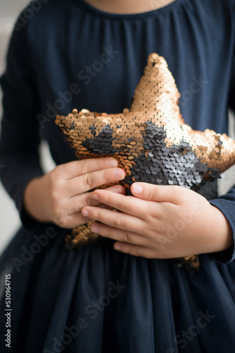 A star with sequins in the hands of a child