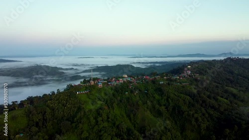 Aerial shot of the mountain Lushai Heritage Village and Sajek valley on a foggy day photo