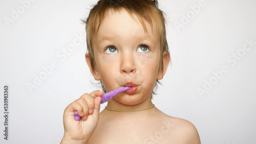 A portrait of a cute boy brushing his teeth